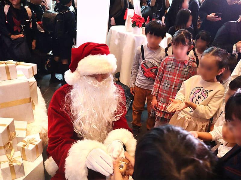 子どもたちにプレゼントを手渡しするサンタさん